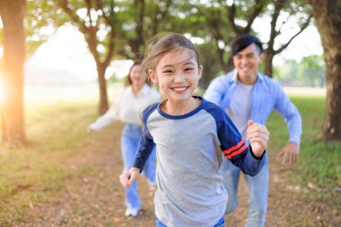 Mutlu Aile parkta koşuyor ve birlikte oynuyor.