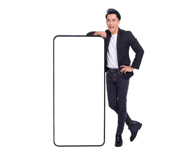 幸せな若い男立って 空白の白い画面で大きなスマートフォンをリース — ストック写真