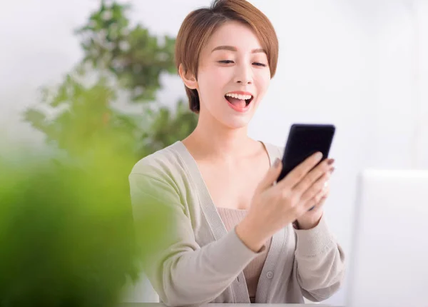 Krásná Vzrušená Mladá Žena Sleduje Mobilní Telefon Obývacím Pokoji — Stock fotografie