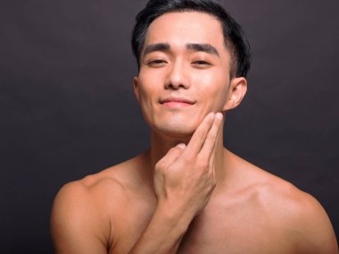 Tıraşlı, pürüzsüz, yumuşak tenli, kendinden emin, yakışıklı bir erkeğin dokunuşuna yaklaş. 