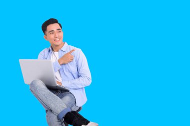 Sıradan giyinen ve dizüstü bilgisayarla çalışan şık bir adam. 