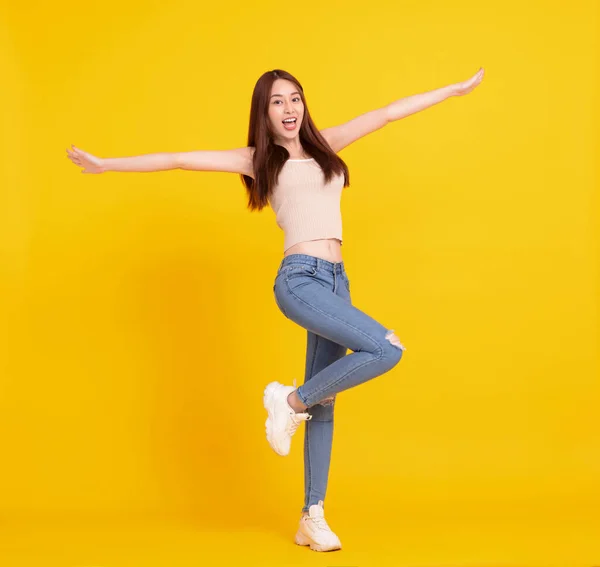 快乐的亚洲女孩跳起来庆祝与黄色隔离 — 图库照片