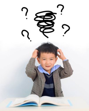 Ev ödevi yapıp evde ders çalışan kafası karışmış bir çocuk.