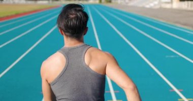  Stadyumun spor pistinde koşan genç koşucunun arka görüntüsü