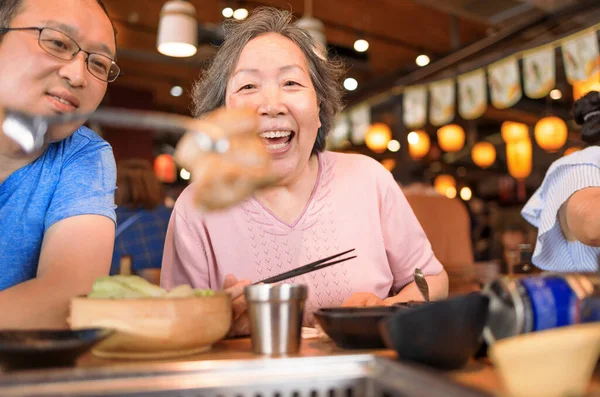 Mutlu anne ve oğul yemek yiyor ve restoranda anneler gününü kutluyor.