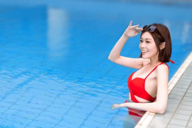 Yüzme havuzunda gülümseyen Asyalı güzel bir kadın.