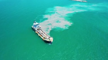   Aerial view of cargo ship leaves the side leaving a mud, Pollution, brown Muddy water behind it