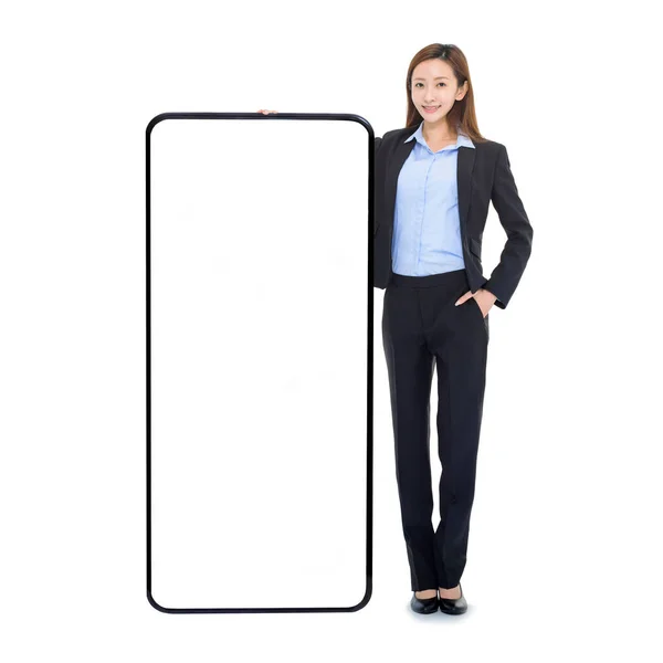 白い画面の巨大な携帯電話にもたれているビジネス女性 スマートフォンのための素晴らしい新しいアプリやウェブサイトをお勧めします — ストック写真