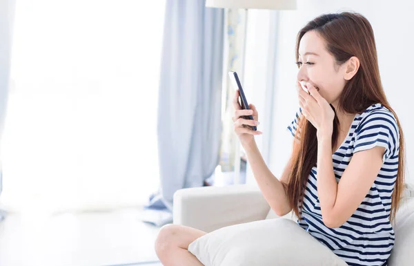 Έκπληκτη Νεαρή Γυναίκα Κοιτάζοντας Οθόνη Smartphone Στον Καναπέ Στο Σπίτι — Φωτογραφία Αρχείου