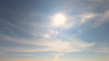 Parlak güneş ışığının zaman aşımı, gün batımı bulutlarının arasından parlayan güneş ışınları yaz mevsiminde güneşli mavi gökyüzü arka planında bulutlar.