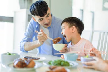 Mutlu baba ve oğul evde yemek yiyor.