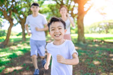 Happy boy  Jogging with parents in the city park