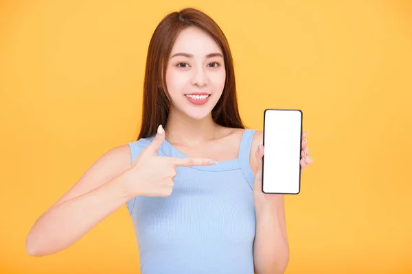 Glücklich Asiatische Frau Zeigt Handy Leeren Bildschirm Auf Gelbem Hintergrund — Stockfoto