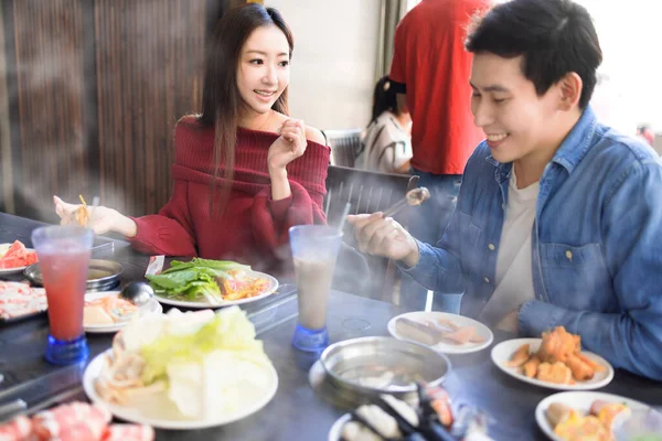 一对快乐的年轻夫妇在火锅餐厅吃饭 — 图库照片