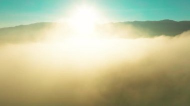 Bulutların arasında uçmak ve güneşin doğuşunda dağın havadan manzarası