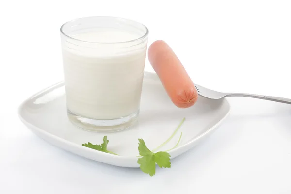 Milch und Wurst auf einem Teller — Stockfoto