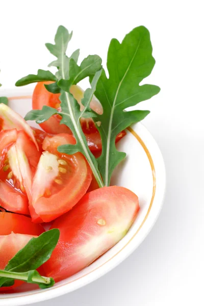 Salade de tomates avec roquette dans une tasse blanche — Photo