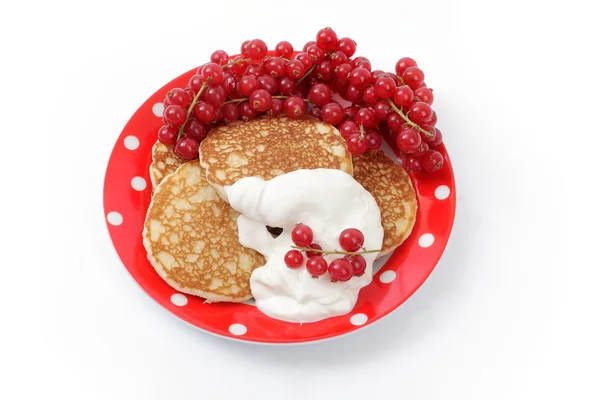 Fritters with sour cream and a red currant — Stock Photo, Image