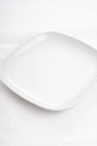 화이트 냅킨에 빈 흰색 접시 — 스톡 사진