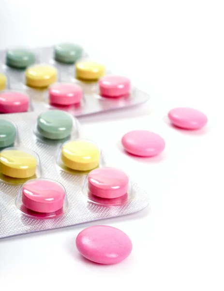 Pink, yellow and green tablets on a white background — Stock Photo, Image