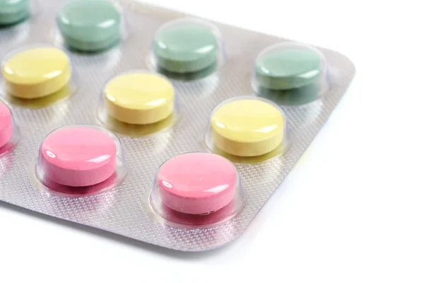 Różowe, żółte i zielone tabletki na białym tle — Zdjęcie stockowe