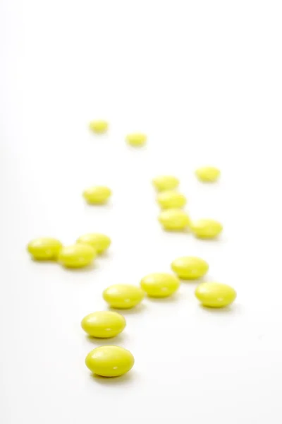 Žlutá lékařská tablety, přes bílý — Stock fotografie