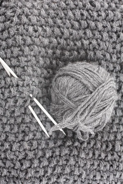 Boule de laine pour tricot et aiguilles sur les articles tricotés — Photo