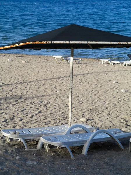 Lege ligstoelen op een keienstrand — Stockfoto