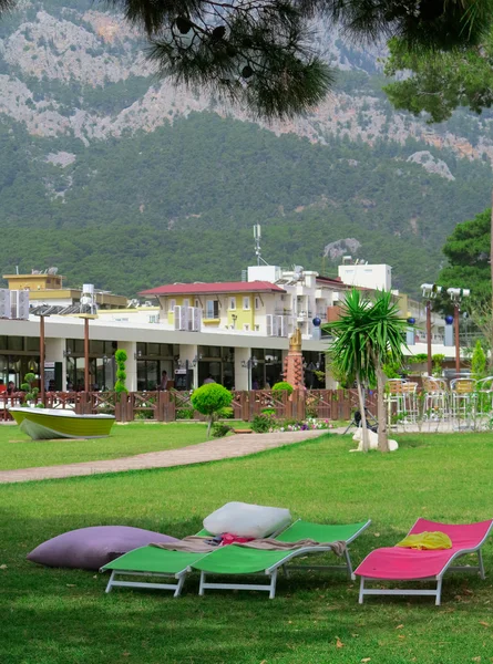 Sunbeds are on the green lawn in front of the hotel on the backg — Stock Photo, Image