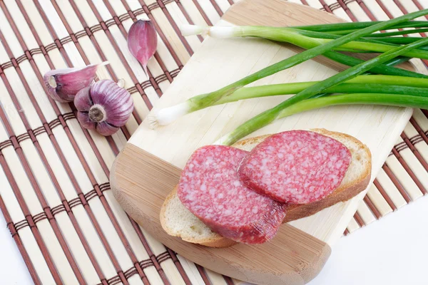 Сендвіч з копченою ковбасою на подрібненій дошці — стокове фото