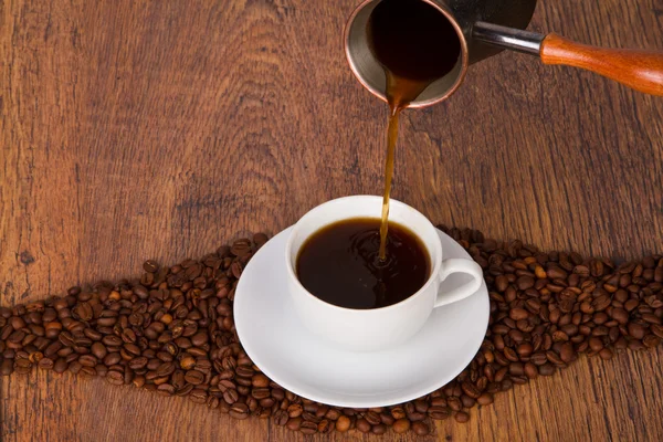 Kaffee in Tasse gießen — Stockfoto