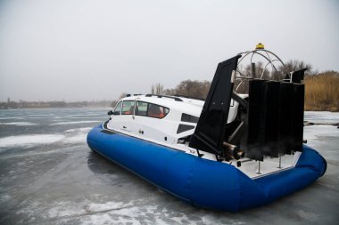 Hovercraft, gölün donmuş buzlu yüzeyinde bir yolculuğa hazır. Kışın kurtarma ekibinin aracı.