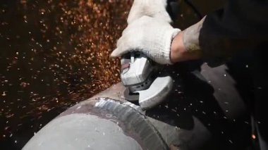 Büyük metal boruları kaynak yaptıktan sonra kaynak dikişlerini temizliyorum. İşçi bu işi bir üçkağıtçıyla yapıyor.