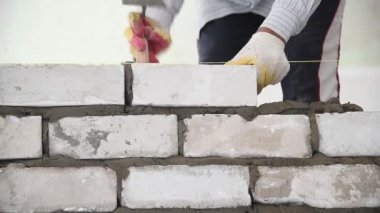 Duvarcı işçisi dış duvara tuğla döşüyordu. Tuğla döşeyen profesyonel inşaat işçisi.