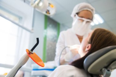 Kadın diş tedavisi görüyor. Diş sağlığı kliniği. Diş tedavisi. Diş hekimi çalışıyor.
