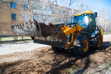 Eskisinin tamiri ve yeni bir asfalt yol inşaatı. Yeni yol inşaatında kazıcılar, grevciler ve yol silindirleri çalışıyor.