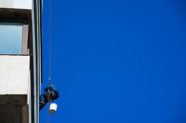 Tırmanışçılar binanın ön cephesinde inşaat ve montaj çalışmaları yapıyorlar.