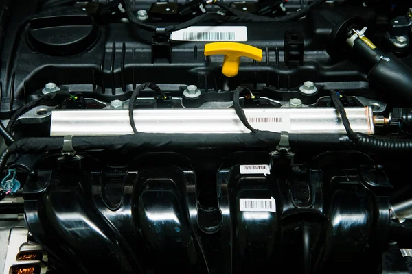 新しい車のエンジンのエンジンオイルレベルをチェックするための明るい黄色のディップスティックハンドル — ストック写真