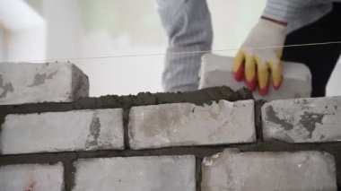 Duvarcı işçisi dış duvara tuğla döşüyordu. Tuğla döşeyen profesyonel inşaat işçisi.