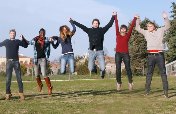 Niños multirraciales saltando felices en el parque —  Fotos de Stock