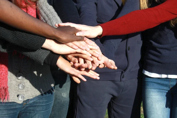 Jeune groupe avec les mains empilées ensemble — Photo