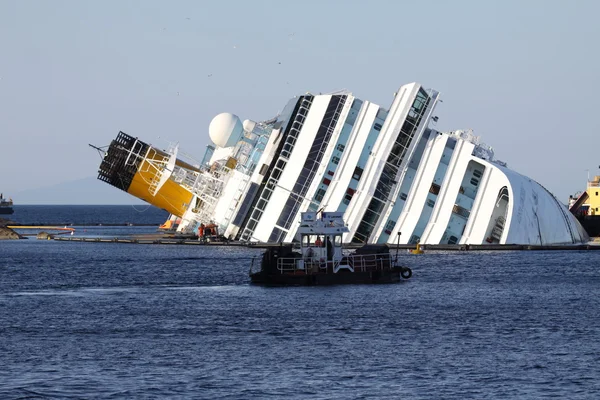 Isola del giglio, Italien - den 15 mars, 2013: fartyget concordia framsidan av hamnen av isola del giglio i italy.some livbåtar runt fartyget Stockbild