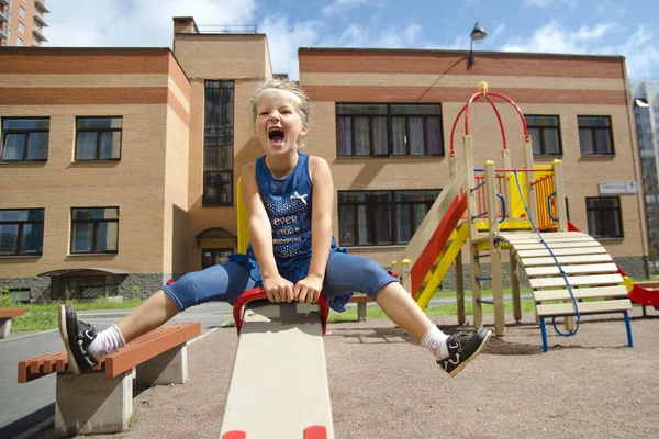 Felice bambina è oscillare su see-saw — Foto Stock