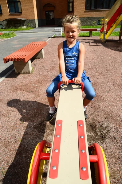 Felice bambina è oscillare su see-saw — Foto Stock