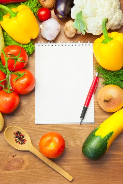 Biologische groenten op houten tafel en notebook — Stockfoto