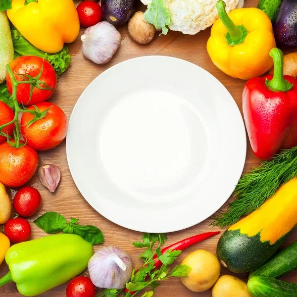 Légumes biologiques frais autour de la plaque blanche — Photo