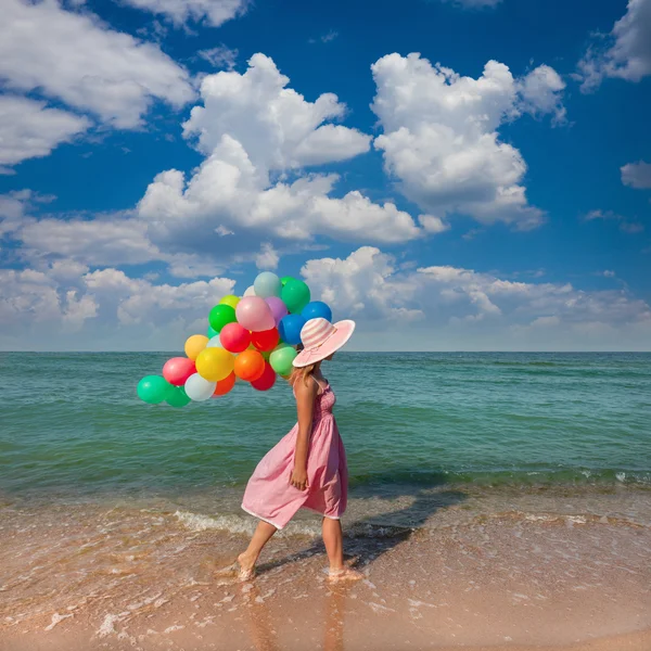 Mujer joven caminando en la playa con globos de colores - Viajar — Foto de Stock