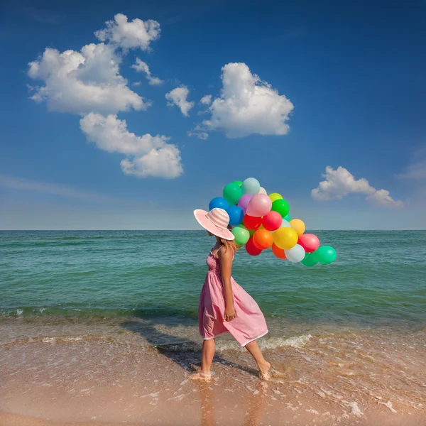 Genç bir kadın ile Sahilde yürüyüş renkli balonlar - relax — Stok fotoğraf