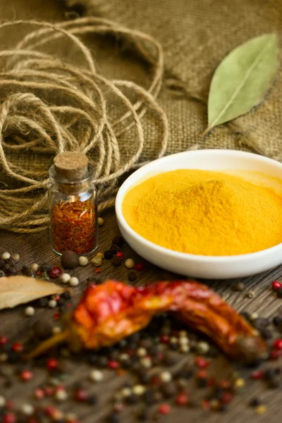 Turmeric in saucer with spices and paprika — Stock Photo, Image