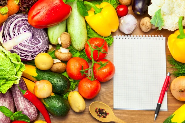 Legumes frescos em fundo de madeira e caderno — Fotografia de Stock